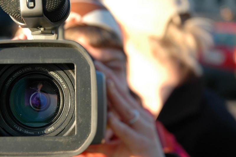 Оператор репортер видокамера с видеокамерой в руках очевидец свидетель