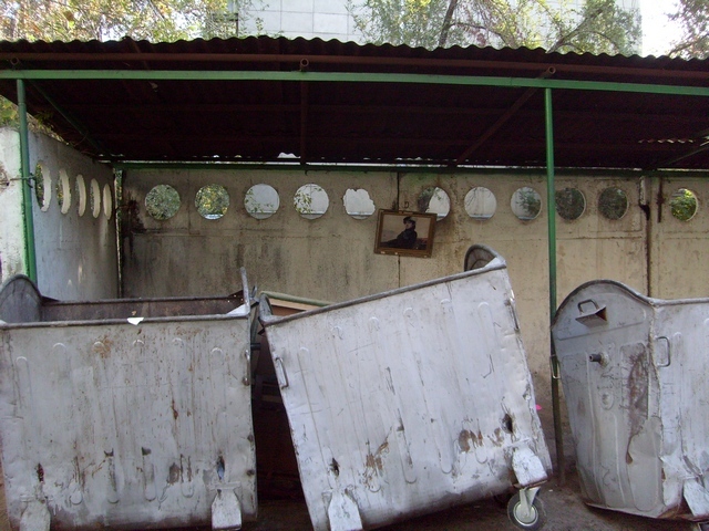 Фотография Рустама Ниязова: картина, висящая на мусорке, Алматы
