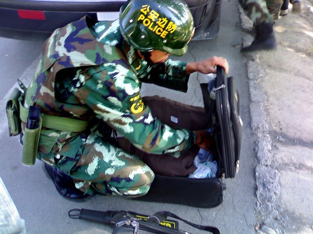 Фото Рустама Ниязова: полицейский обыскивает вещи по дороге на Урумчи