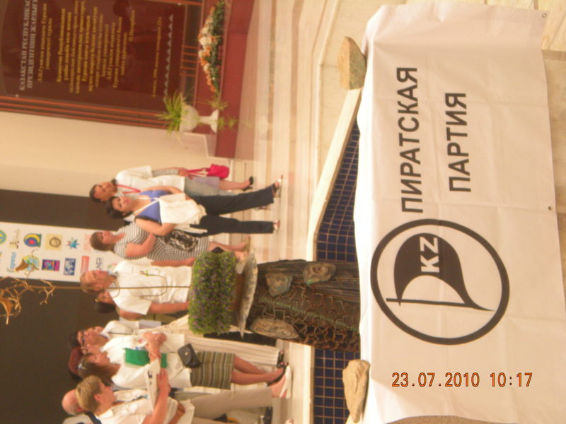 Баннер Пиратской Партии Казахстана укрепленный с двух сторон камнями и участники SocialCamp.